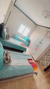 Cette petite chambre comprend deux lits et une table. dans l'établissement Spacious 2-bedroom apartment, à Tetouan