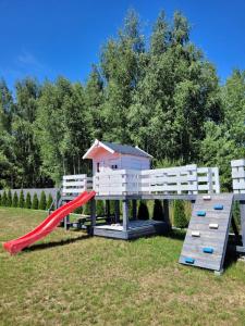 a playground with a slide and a play house at Villa Grunwald in Gierzwałd