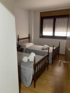 - une chambre avec 2 lits et une fenêtre dans l'établissement Apartamento Duplex O capitán, à A Guarda