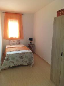 a small bedroom with a bed and a window at Cal Cucu in Gerp