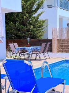コーラル・ベイにある3 Bedroom Coral Bay Beach Seaview Villa II Private Poolのスイミングプールの横に青いテーブルと椅子