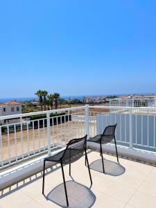 duas cadeiras sentadas no topo de um telhado em 3 Bedroom Coral Bay Beach Seaview Villa II Private Pool em Coral Bay