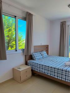 a bedroom with a bed and two windows at 3 Bedroom Coral Bay Beach Seaview Villa II Private Pool in Coral Bay