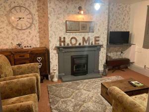 a living room with a fireplace and a home sign at Main Street 2 bedroom town house in Llandeilo