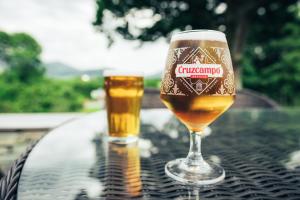 un vaso de cerveza sentado en la parte superior de una mesa en The Ruddings en Keswick