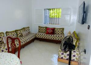 ein Wohnzimmer mit einem Sofa und einem Fenster in der Unterkunft Charming apartment with a small garden in Tangier