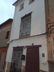 un edificio blanco con dos ventanas y una puerta en CaPepica en Ráfol de Salem