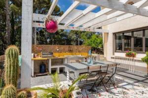 d'une terrasse avec une table, un grill et un cactus. dans l'établissement Villa Magali grande terrasse vue mer, jardin, proche port, à La Ciotat