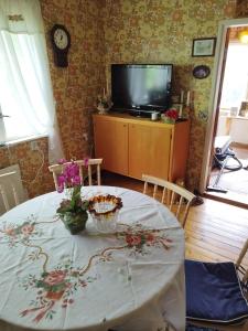 - une table à manger avec une télévision et des fleurs dans l'établissement Mysig Stuga På Houtskär, à Houtskari
