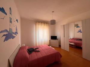 1 dormitorio con 1 cama con colcha roja en Gambero Blu, en Piano di Follo