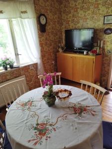 uma mesa com uma toalha de mesa branca e flores sobre ela em Mysig Stuga På Houtskär em Houtskari