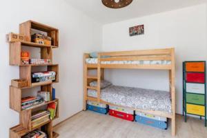 ein Schlafzimmer mit 2 Etagenbetten und einem Bücherregal in der Unterkunft Villa Magali grande terrasse vue mer, jardin, proche port in La Ciotat