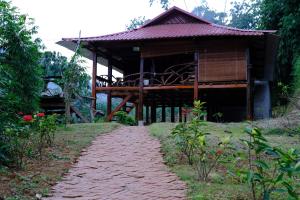 un pequeño edificio con un camino delante de él en Homestay Toan Tra Tram Tau en Cham Ta Lao