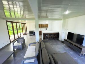 a living room with couches and a flat screen tv at La Casa Pina Pacifica near La Fortuna in San Ramón