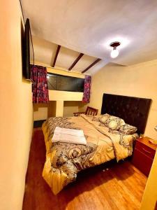 um quarto com uma cama e uma televisão em Apartment em Cusco