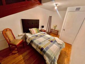 um quarto com uma cama e uma cadeira em Apartment em Cusco