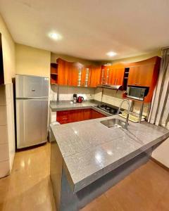 uma cozinha com armários de madeira e um frigorífico de aço inoxidável em Apartment em Cusco