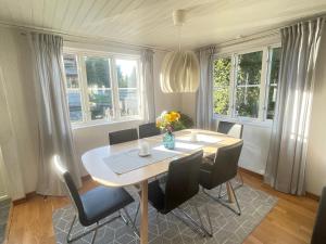 une table à manger avec des chaises et un vase de fleurs dans l'établissement Lovely Waterfront Cottage near Karlshamn, à Asarum