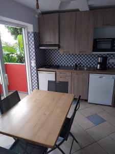 a kitchen with a wooden table and some chairs at Stephane in Pointe-Noire