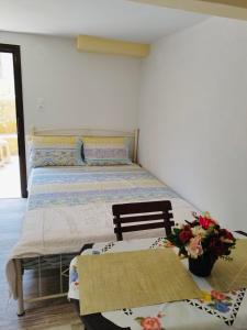 una camera con due letti e un tavolo con fiori di Elisavet Room Portiano a Pedhinón