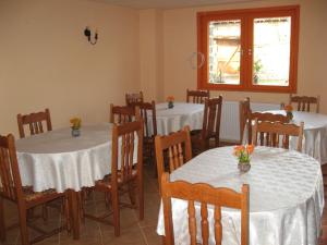 un comedor con mesas y sillas con mantel blanco en Elefterova kashta, en Arbanasi