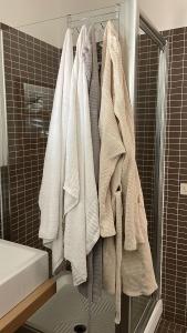 un gruppo di asciugamani appesi a un appendiabiti in bagno di Casa Vacanza a Palermo