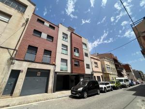テラサにあるCozy apartment well-located in Terrassa, Barcelonaの路上の建物前に駐車した車