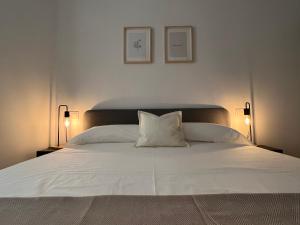 a bedroom with a white bed with two lamps at Cozy apartment well-located in Terrassa, Barcelona in Terrassa