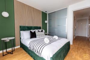 a bedroom with a large bed with a green wall at Stunning 1-bed, Central MK, Free Parking, Smart TV By Valore Property Services in Milton Keynes