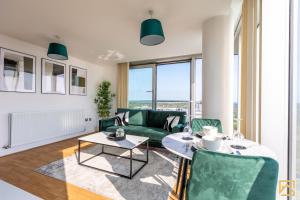 a living room with a green couch and a table at Stunning 1-bed, Central MK, Free Parking, Smart TV By Valore Property Services in Milton Keynes