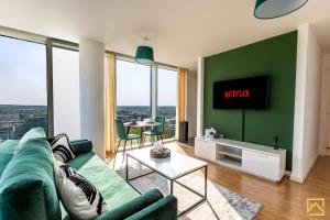 a living room with a couch and a tv on a wall at Stunning 1-bed, Central MK, Free Parking, Smart TV By Valore Property Services in Milton Keynes