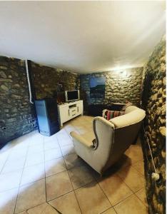 - un salon avec un canapé dans une pièce aux murs en pierre dans l'établissement Affittacamere Dodo, à Villafranca in Lunigiana