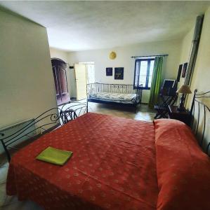 1 dormitorio con 1 cama con colcha roja en Affittacamere Dodo, en Villafranca in Lunigiana