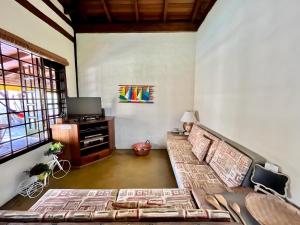 uma sala de estar com um sofá e uma televisão em Casa de temporada estilo rústico - Litoral Norte de SP em São Sebastião