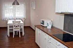 a kitchen with a microwave and a table with chairs at Pokoje Gościnne Ruciane-Nida in Ruciane-Nida