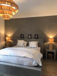 a bedroom with a white bed with two lamps at VILLA PISCINE MARRAKECH in Marrakesh