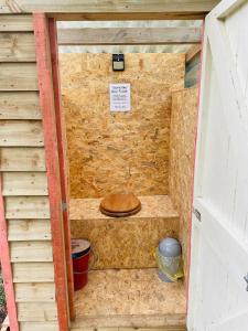 a sauna with a wooden toilet in a brick wall at Robin Goch Retreat in Carmarthen +2 photos