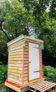 a wooden out house with a door on a trailer at Robin Goch Retreat in Carmarthen