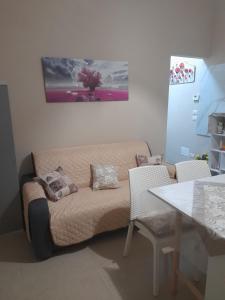 uma sala de estar com um sofá e uma mesa em Casa del sole em Barletta