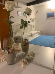 a table with a vase with flowers and a mirror at BeB CASABARBARA a due passi dal mare in Lerici
