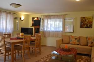 a living room with a table and a couch and a dining room at Guest House Mary in Porto Heli