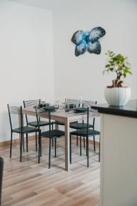 tavolo da pranzo con sedie nere e farfalla sul muro di Casa vacanze La Farfalla a San Vito Chietino