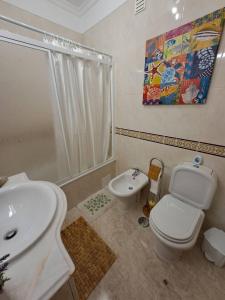 uma casa de banho com um WC, um lavatório e um chuveiro em T2 Vila Atlântida Praia Vilamoura em Quarteira