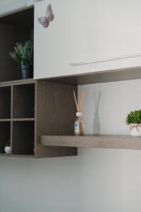 a white cabinet with wooden shelves with plants on it at Casa vacanze La Farfalla in San Vito Chietino