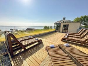 una terrazza con 2 panche e un gazebo di Appartements "Zum Leuchtturm" Hafen Rankwitz Insel Usedom a Rankwitz