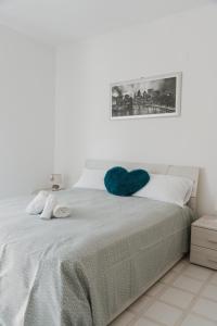 Una cama con una almohada azul del corazón. en Casa vacanze La Farfalla, en San Vito Chietino
