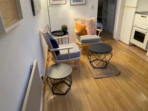 a living room with two chairs and two tables at San Bernabé, apartamento para 2 en las Vistillas junto a metro Puerta de Toledo in Madrid