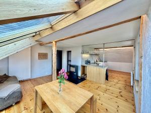 Una habitación con una mesa con un jarrón de flores encima. en Atelierhaus Meißen, en Meißen