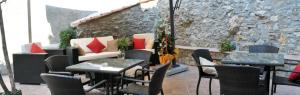 a restaurant with tables and chairs and a stone wall at Bed and Breakfast Rio Casaletto in Casaletto Spartano