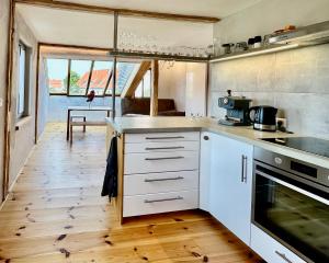 a kitchen with white cabinets and a wooden floor at Atelierhaus Meißen in Meißen